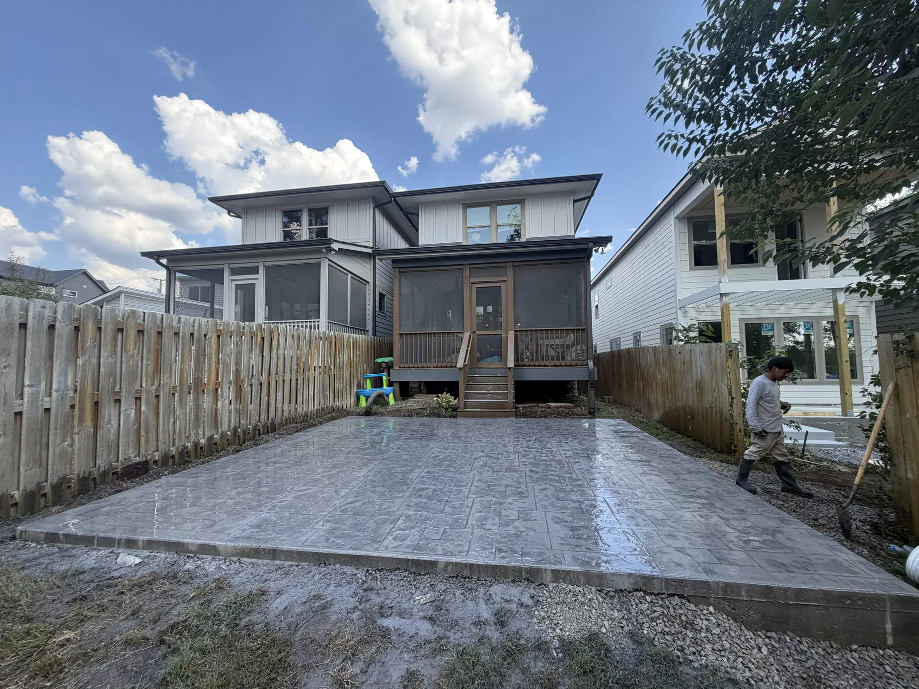 Large decorative stamped concrete patio behind a home