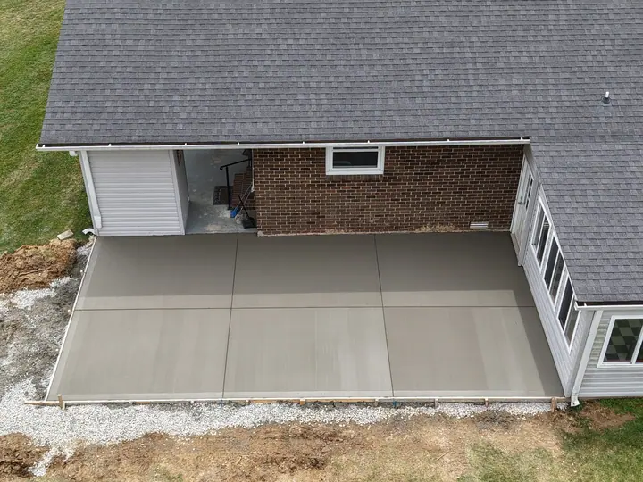 Newly finished concrete patio beside a home, photographed from above