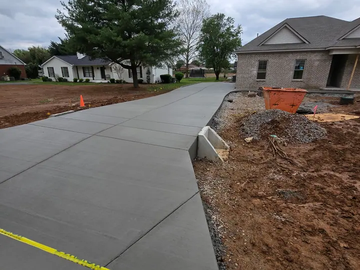Fresh concrete driveway leading toward a garage