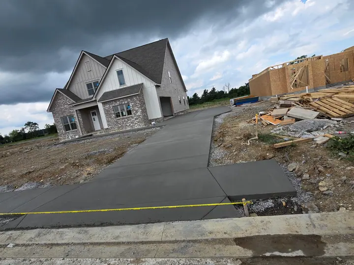 Fresh concrete driveway in front of a residential construction site