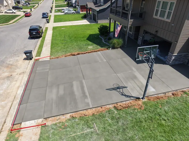 Finished concrete driveway with a basketball hoop in a neighborhood
