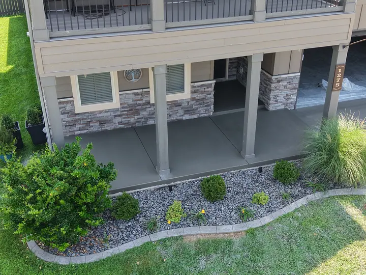 Finished front-entry concrete porch beneath a covered area