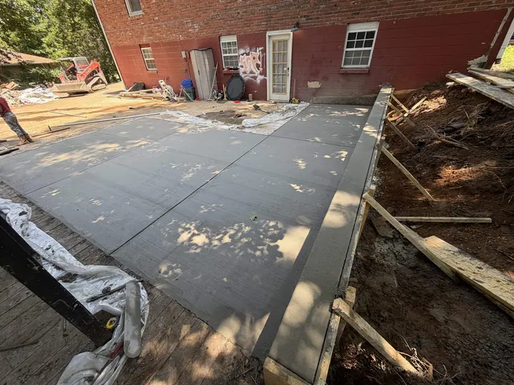 Newly poured and sectioned concrete slab with forms along its edge