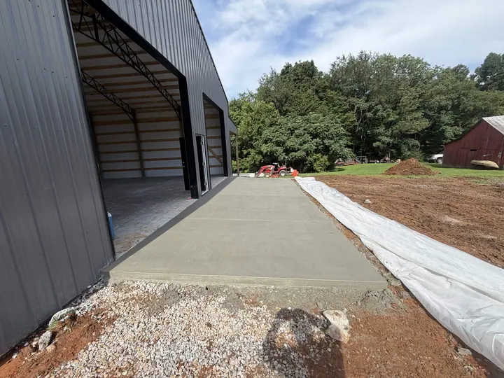 Fresh concrete slab outside a metal building