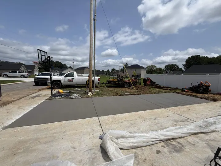 Freshly poured concrete paving near a residential work area