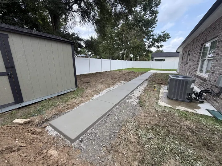 Concrete walkway leading toward a back yard