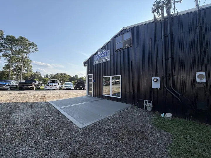Concrete driveway alongside a dark metal building