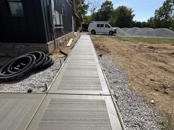 Fresh sectioned concrete sidewalk running alongside a building