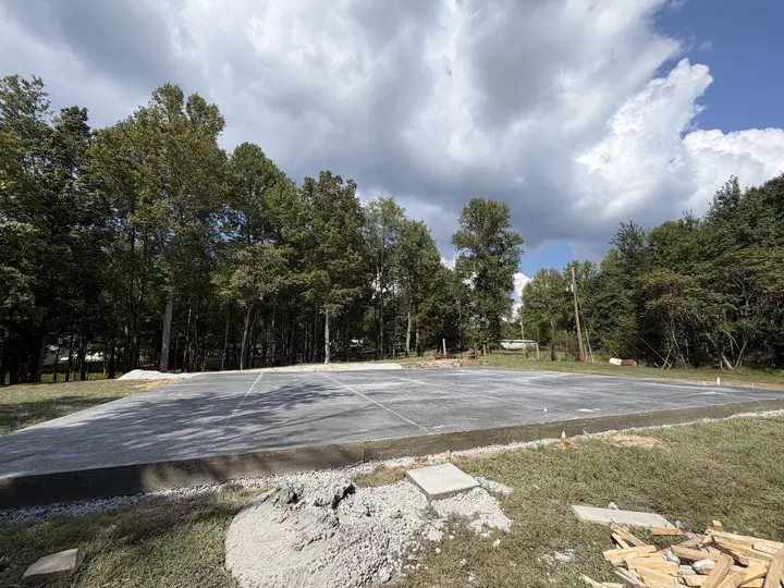 Wide finished concrete slab with wooded background