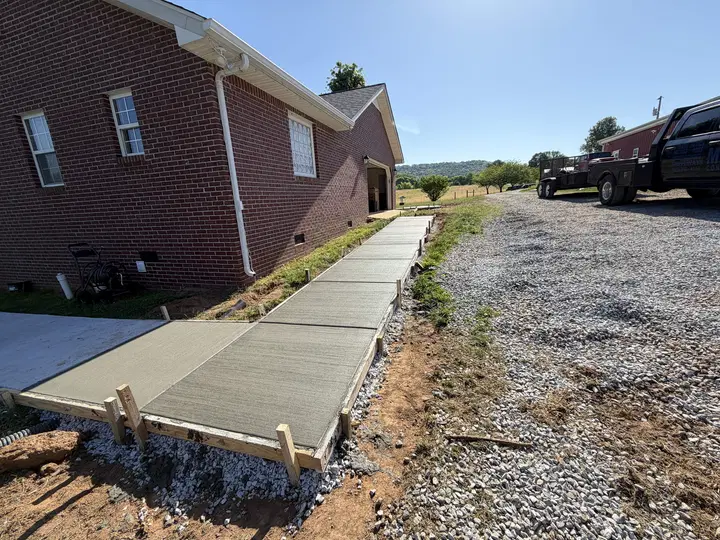 Fresh sidewalk running beside a brick residential building