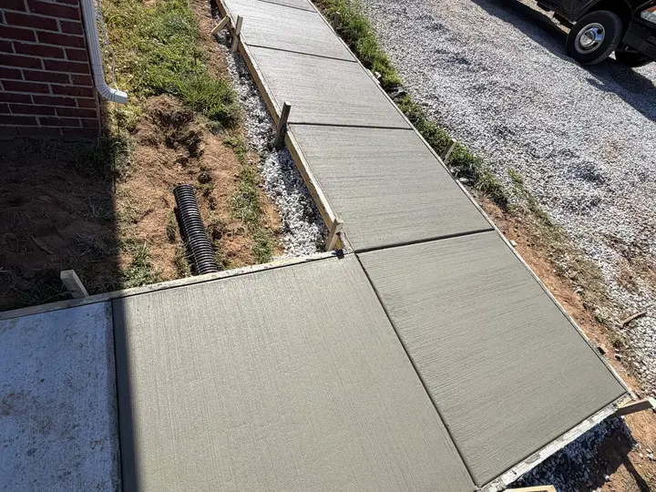 Straight concrete path from a driveway toward a house