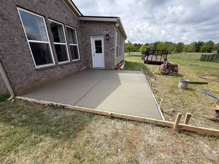 Fresh concrete patio next to a brick house