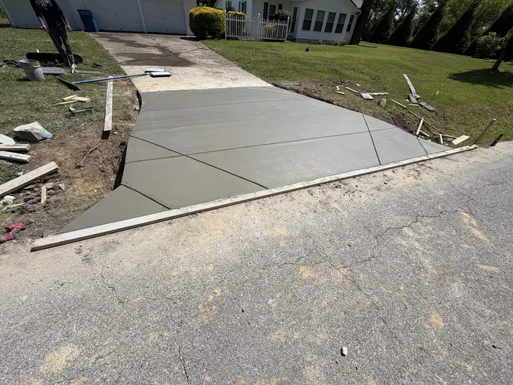 Concrete driveway extension with rounded edge at a residential property