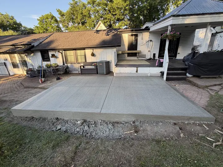 Newly poured wide patio slab behind a home