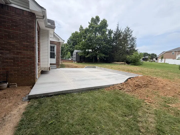 Angular concrete patio beside a brick residence